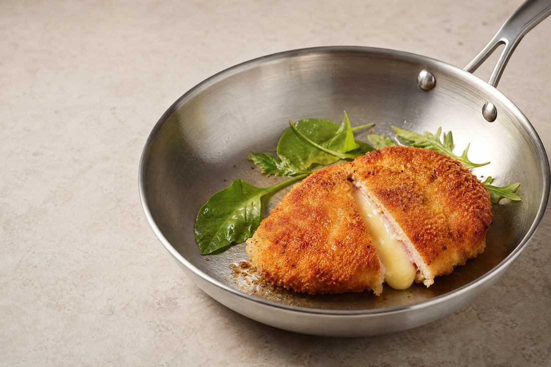 Cordon-bleu doré dans une poêle en inox, fromage fondu au centre