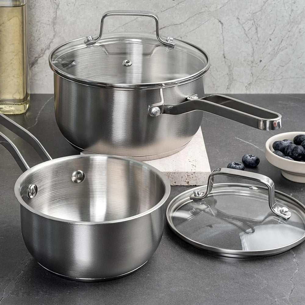 Casserole en inox de 16 cm et son couvercle en verre, sur un plan de travail