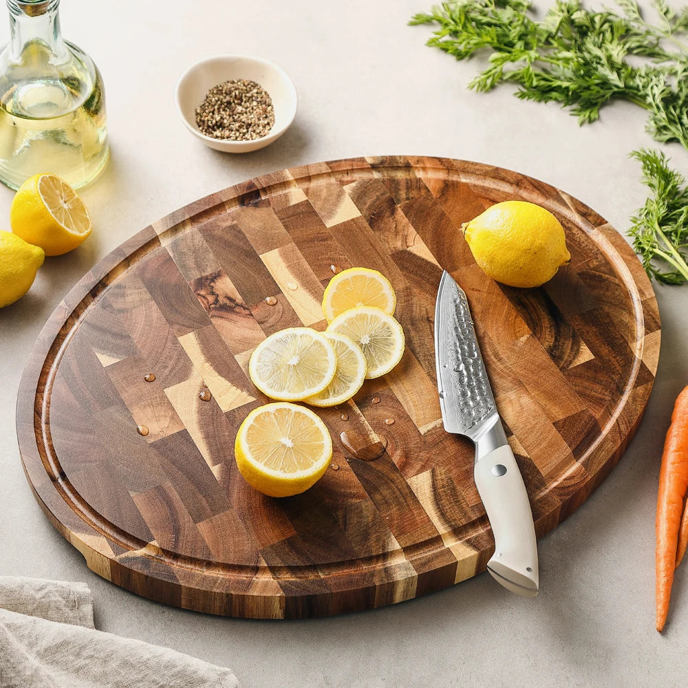 Grande planche ovale en bois de bout d'acacia avec citrons et couteau