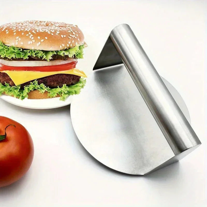 Presse à burger en inox à côté d'un burger