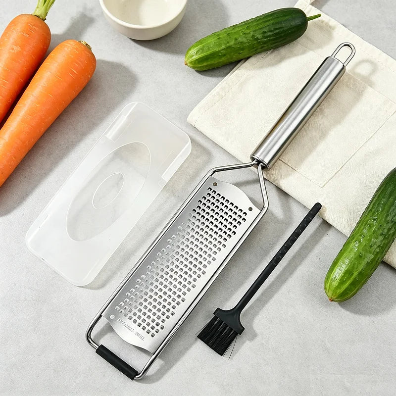 Râpe zesteur en inox, étui et brosse, près de légumes