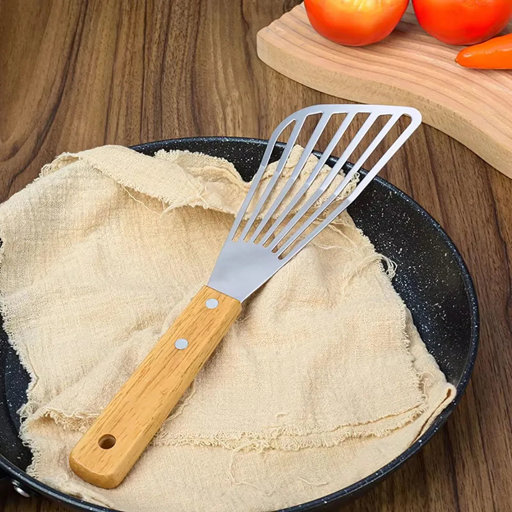 Spatule ajourée en inox posée dans une poêle