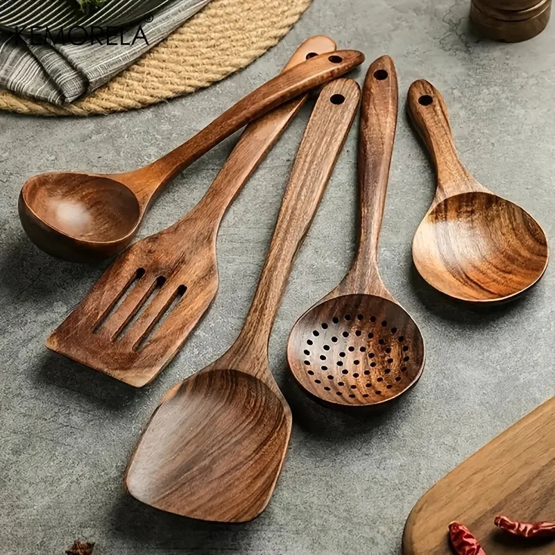 Spatules, louche, écumoire et cuillère en teck posées sur une table